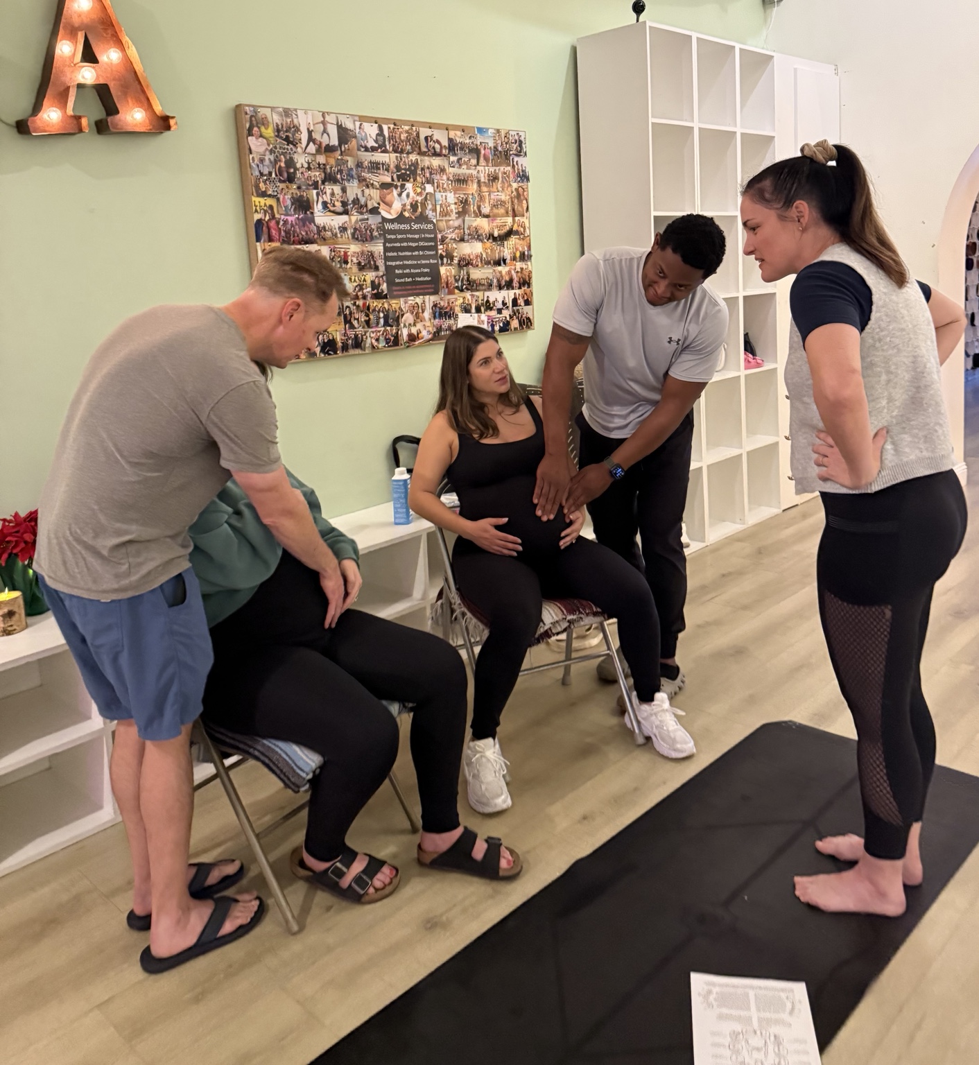 A small group practicing hands-on comfort measures with a pregnant participant