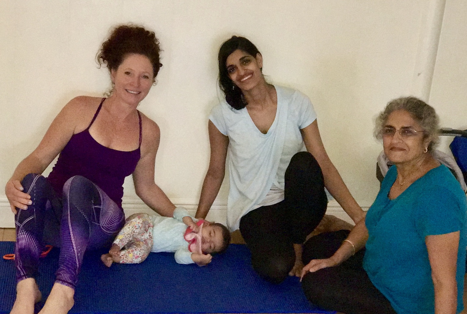 Lisa with a mother, baby and grandmother after a community yoga practice