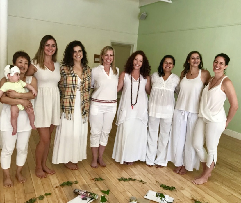 Lisa and graduates of a MamaShakti prenatal yoga teacher training dressed in white